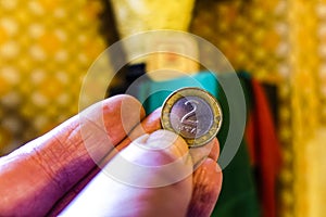 Closeup of a hand holding a coin 2 litas