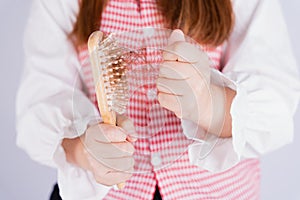 Closeup hand holding comb and hair fall problem isolated grey background