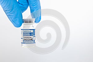 Closeup hand holding Covid Vaccine dose bottle with white space for text