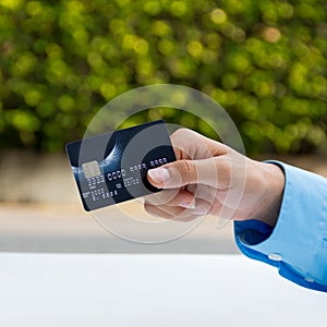 Closeup of hand holding credit card, ready for payment