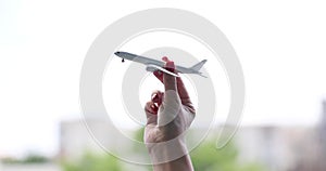 Closeup of hand holding model airplane and flights around world