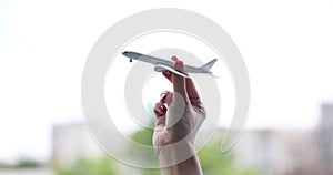 Closeup of hand holding model airplane and flights around world