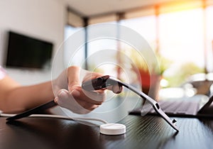 Closeup hand holding smartwatch charging on wireless charger