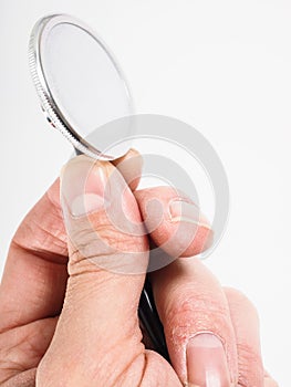 Closeup of hand holding a stethoscope towards bright