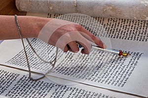 A reader of the Torah uses a yad or pointer as a guide photo