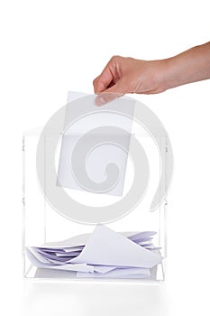 Closeup of hand inserting ballot in box