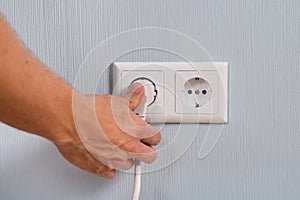 Closeup of hand inserting an electrical plug