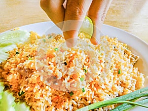 Closeup Hand with lemon on fried rice