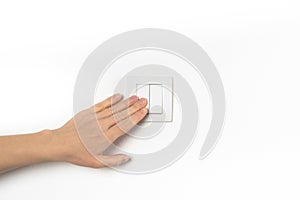 Closeup of hand and light switch. Womans hand with fingers on light switch, about to turn off the lights. Horizontal format. White