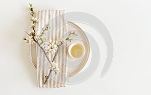 Closeup of hand made herbal almond oil. Almond twigs white table background. Spa concept. Skin product mockup scene