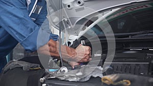 Closeup hand of man is mechanic repairing engine of car in the garage, auto service.