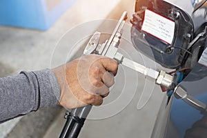 Hand of man pumping CNG gas in car at gas station