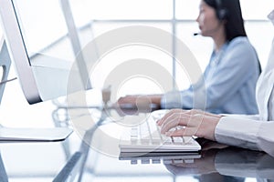 Closeup hand officer typing record customer data in computer CRM software. People call center working in office  for hotline or