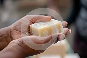 closeup of a hand passing a solid shampoo bar to another