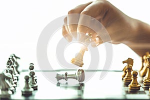 Closeup hand playing chess boardgame checkmate for win business concept