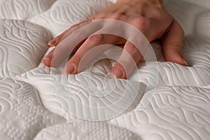 closeup of a hand pressing down on an orthopedic pillow, highlighting firmness photo