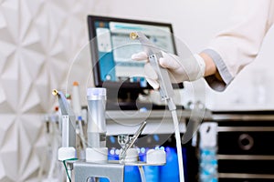 Closeup of hand of professional female cosmetologist holding modern peeling equipment, microdermabrasion. Modern skin