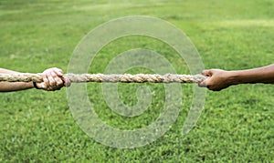 Closeup of hand pulling the rope in tug of war game photo