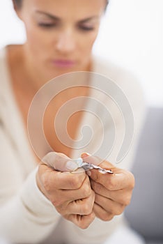 Closeup on hand pushing pill out of blister package