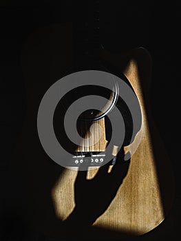 Closeup of a hand shadow strumming on guitar strings