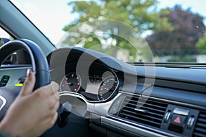 Closeup of a hand on the steering wheel in a car