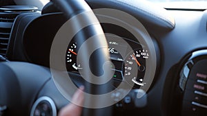 Closeup of hand on the steering wheel and speedometer