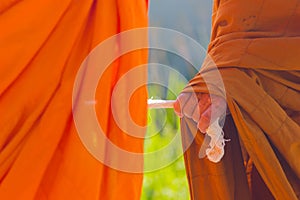 Closeup hand of Thai monk holding big rope leading people to the