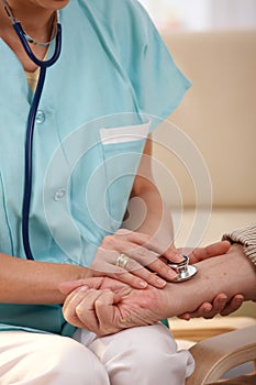 Closeup of hand using stethoscope on wrist