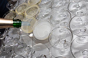 Closeup of the hand of the waiter pouring champagne into glasses