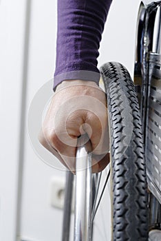 Closeup of hand on wheel of wheelchair