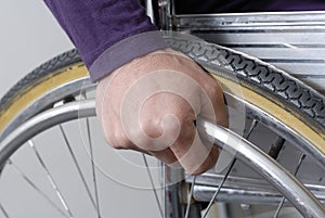 Closeup of hand an wheel of wheelchair