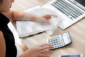 Closeup hand woman calculating expenses household and writing notebook on desk, girl checking bill and stress and note