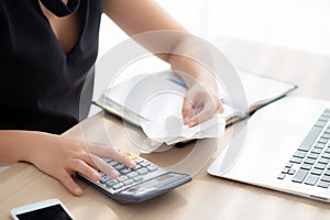 Closeup hand woman calculating expenses household and writing notebook on desk, girl checking bill and stress and note