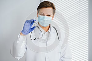 Closeup hand of woman doctor or scientist in doctor's uniform wearing face mask protective in lab holding medicine