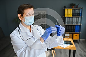 Closeup hand of woman doctor or scientist in doctor& x27;s uniform wearing face mask protective in lab holding medicine