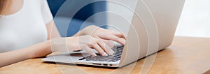 Closeup hand of woman typing keyboard on laptop computer on desk at home, business woman working to internet online.