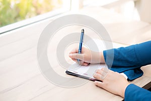 Closeup hand woman writer thinking idea and writing on notebook or diary with happy, lifestyle of asian girl is student