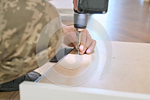 Closeup of hand worker doing furniture, assembling kitchen with professional tools