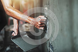 closeup hand of worker plastering cement at wall for building house