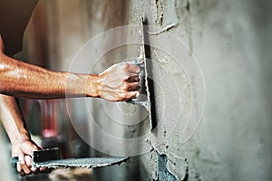 closeup hand of worker plastering cement at wall for building house