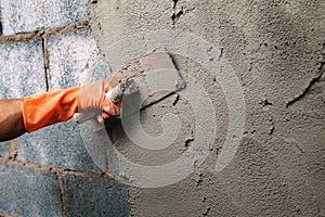 closeup hand worker plastering cement on wall for building house