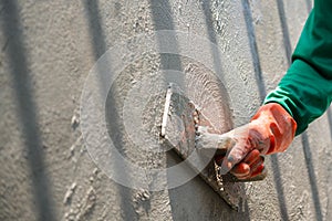 closeup hand of worker plastering cement at wall for building house