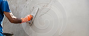 closeup hand of worker plastering cement at wall for building house