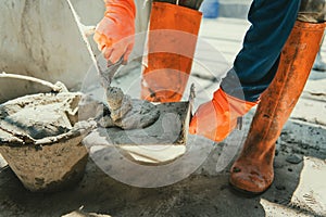 closeup hand of worker plastering cement at wall for building house