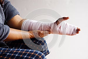 Closeup hand wrapped with bandage on sprain wrist, injury arm treatment.