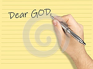 Closeup hand writing letter to GoD on lined sheet