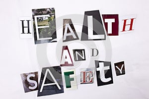 Closeup of a hand writing a message word writing HEALTH and Safety made of different magazine newspaper letter letters for health