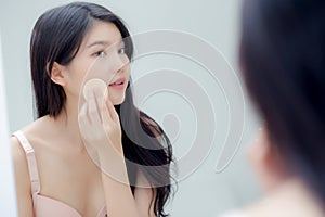 Closeup hand of young asian woman holding product cosmetic applying cream in jar.