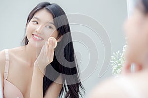 Closeup hand of young asian woman holding product cosmetic applying cream in jar.