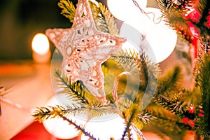 Closeup of handmade christmas decoration on pine tree with warm light